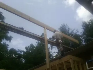 Carpenter setting a ridge beam over a new addition frame — Ice Dam Removal by Roofing Brothers in Jonesboro