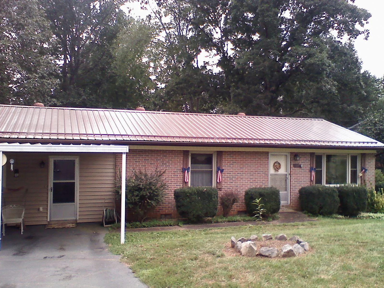 Bronze metal roof and carport on a brick ranch home — Roof Repair work by our crew in Jonesboro