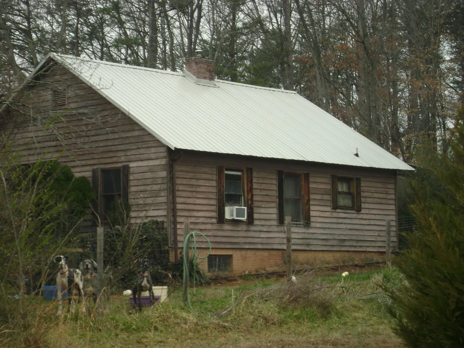 White metal roof on an old wood sided farmhouse, from a Metal Roof Installation job in Jonesboro
